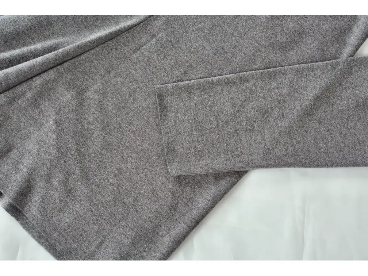 Close-up of the hem and side seam on a grey ribbed top