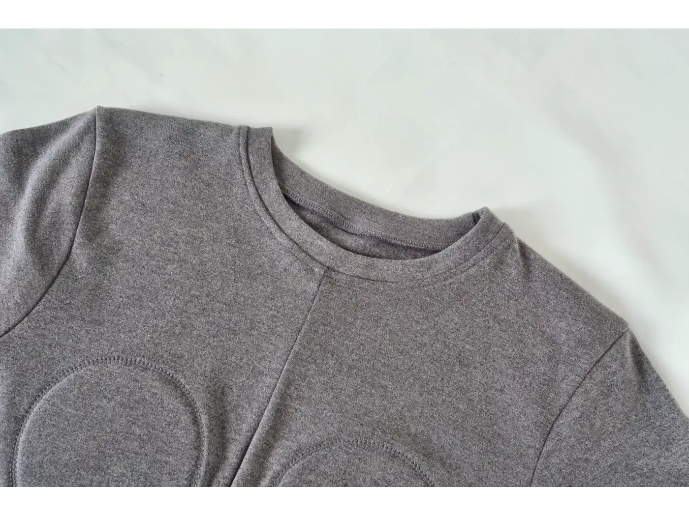 Close-up of the bound neckline and centre front seam on a grey ribbed top