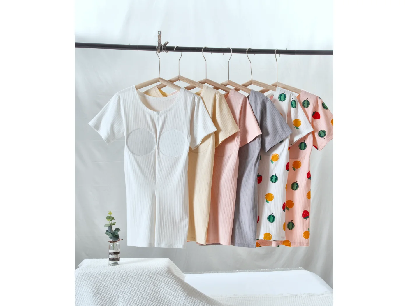 Six colourways of a ribbed short-sleeve top with sewn-in cup padding, hung on a rail